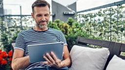 Mann liest auf seinem Tablet