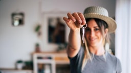 Frau hält einen Schlüssel in der Hand
