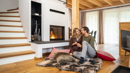 Pärchen vor dem Kamin im Chalet