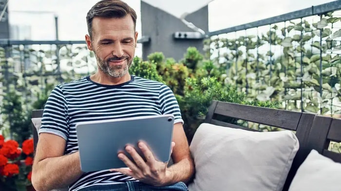 Mann liest auf seinem Tablet