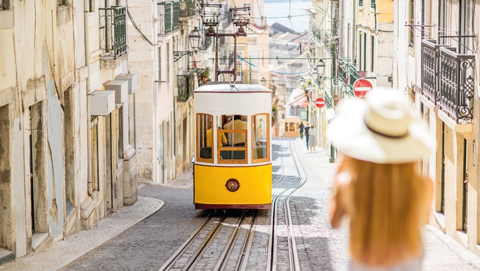 Gelbe Straßenbahn in enger Gasse in Lissabon