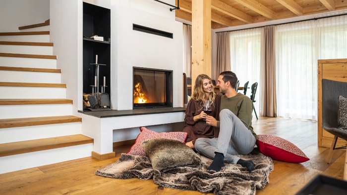 Pärchen vor dem Kamin im Chalet